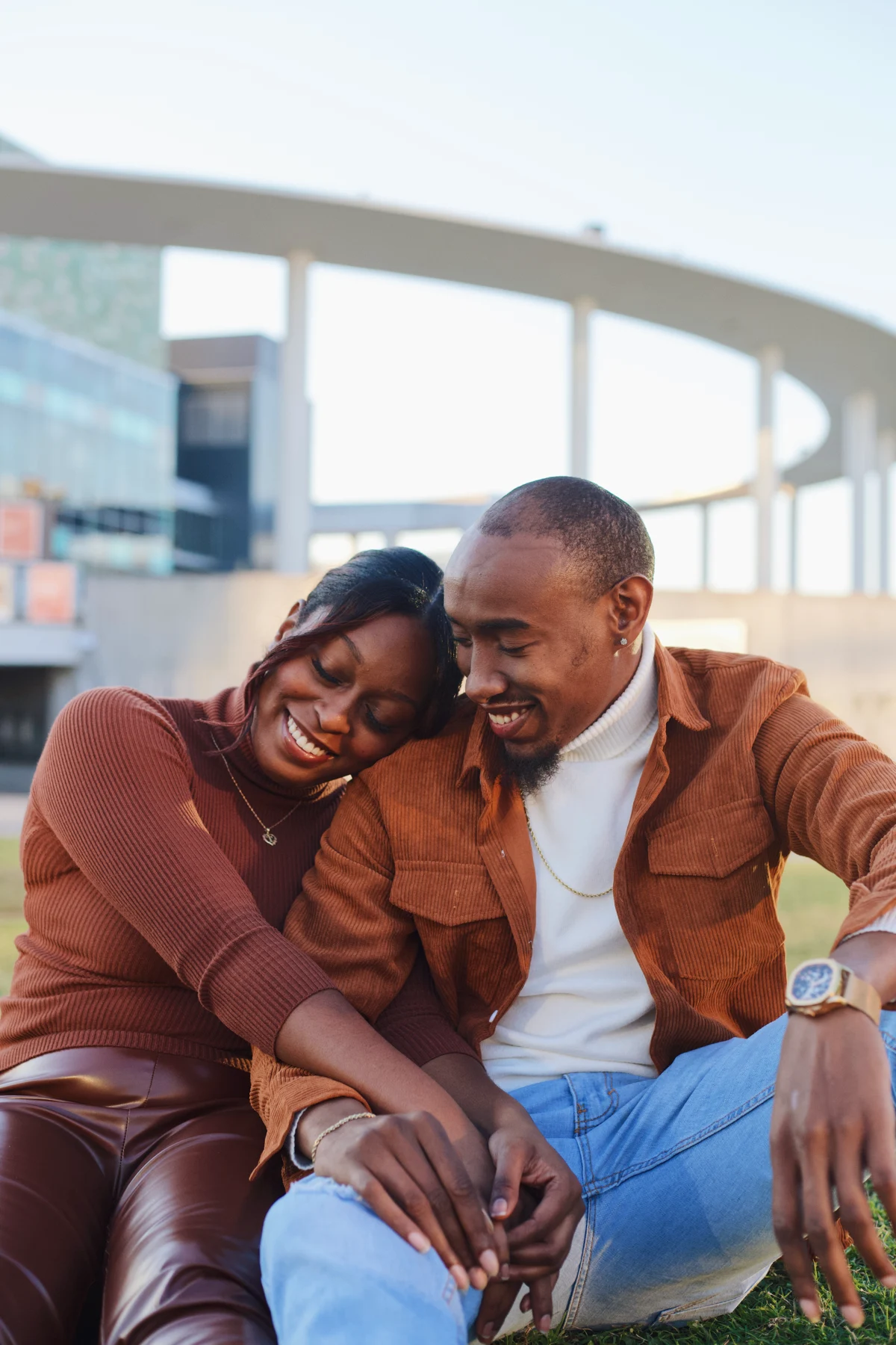 A couple sharing a laugh, leaning together outdoors